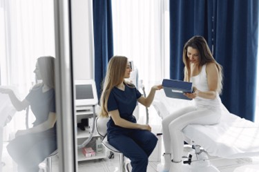 Medica examinando a mujer en una clínica de cirugía estética